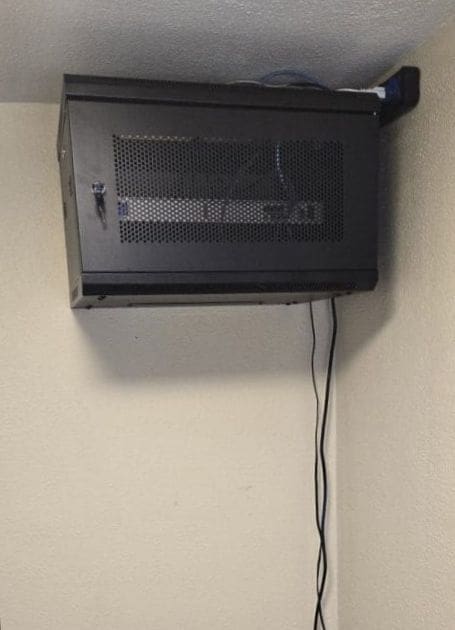 Network equipment securely housed inside an enclosed cabinet after the upgrade at Garyland cottage, showing a clean and organized setup