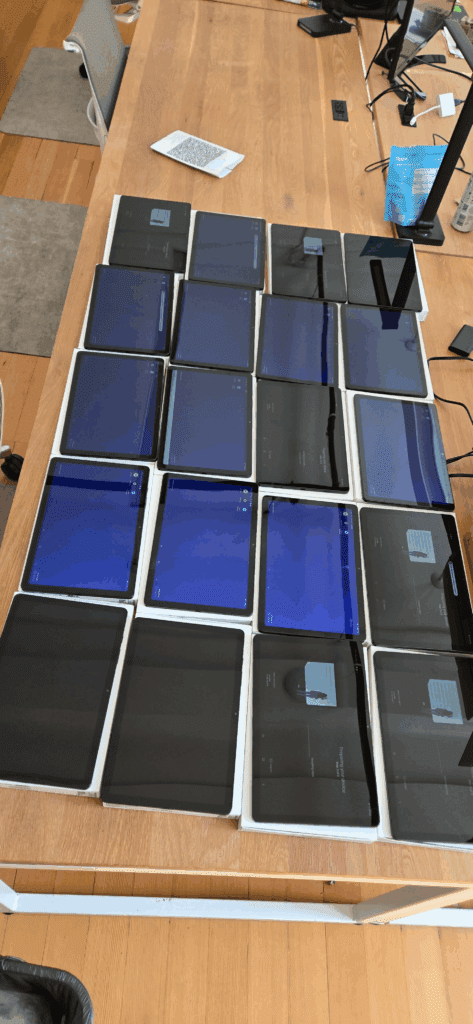 Single table displaying 20 Samsung tablets arranged and ready for provisioning at Joe Coffee office
