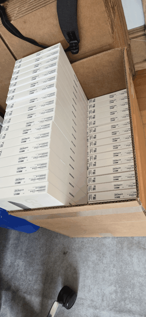 Overview of five tables each holding 20 Samsung tablets during a bulk provisioning session at Joe Coffee