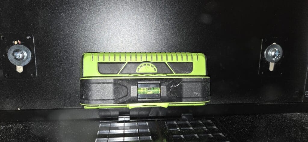 Using a level to ensure the cabinet network is perfectly horizontal during installation